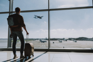 Mann mit Koffer am Flughafen. Anschluss verpasst am Flughafen
