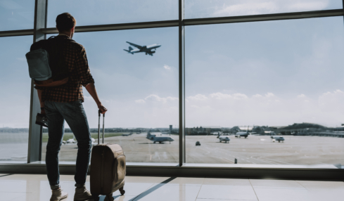 Mann mit Koffer am Flughafen. Anschluss verpasst am Flughafen