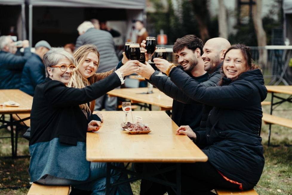 Menschen am Tisch sehen glücklich aus mit Getränk in der Hand.